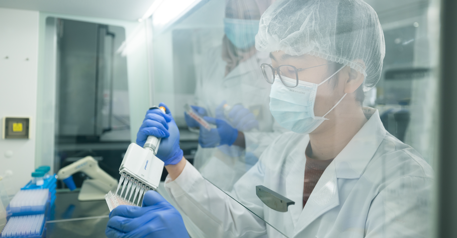 Dr. Tan examining tissue culture in virology laboratory