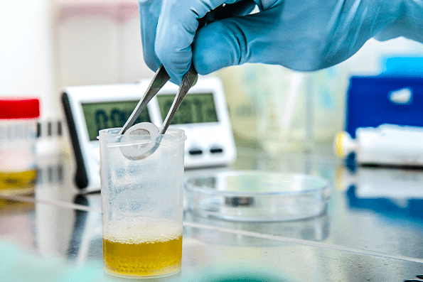 EN 13697 - Viroxy's microbiologist is dipping the metal disc into neutralizer
